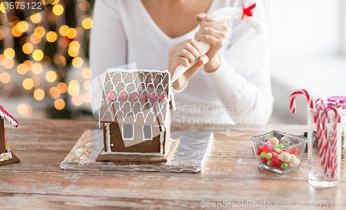 Image of close up of woman making gingerbread house at home
