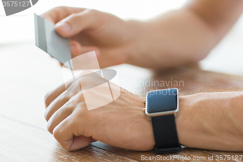 Image of close up of hands with smart watch and credit card