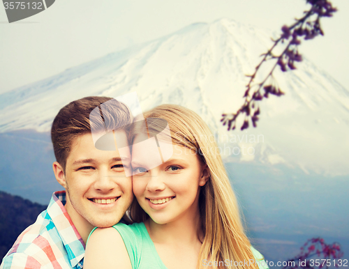 Image of smiling couple hugging over mountains background