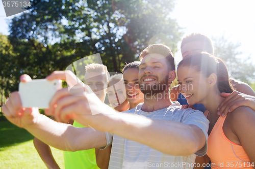 Image of happy friends taking selfie with smartphone