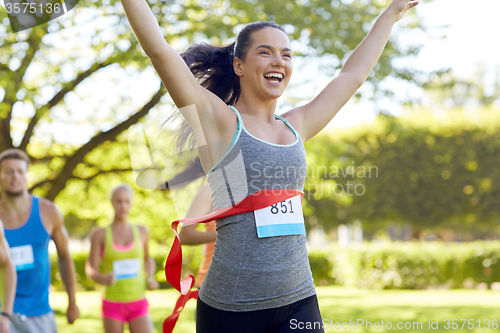 Image of happy young female runner winning on race finish