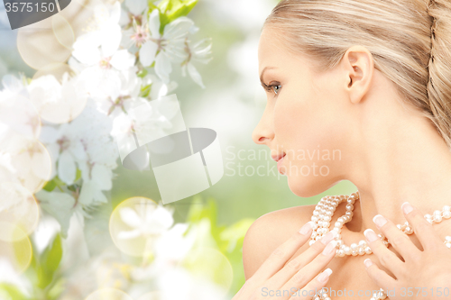 Image of woman with pearl necklace over cherry blossom