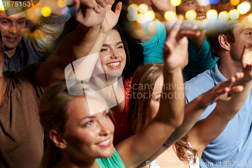 Image of smiling friends at concert in club