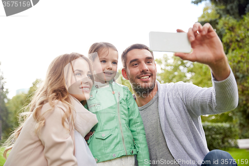 Image of happy family taking selfie by smartphone outdoors