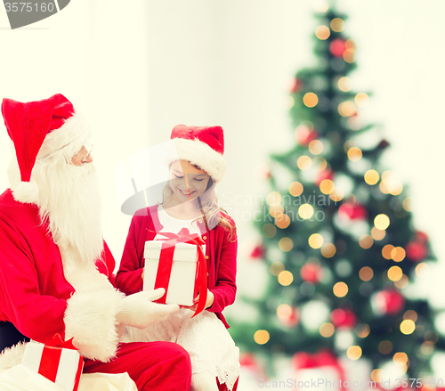 Image of smiling little girl with santa claus and gifts