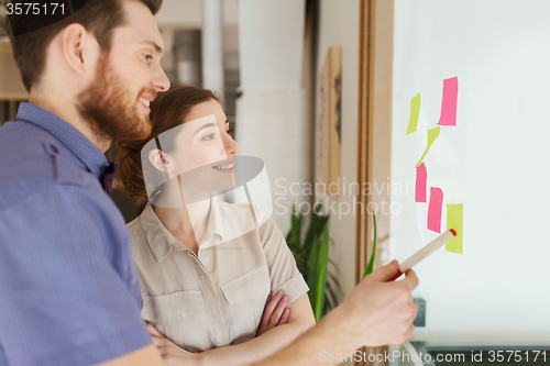 Image of creative team with stickers on glass at office