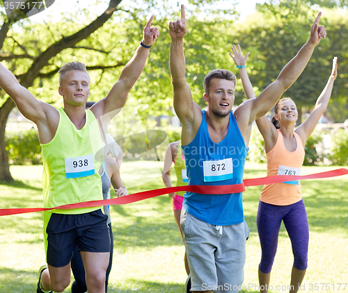 Image of happy young male runner winning on race finish