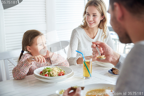 Image of happy family having dinner at restaurant or cafe