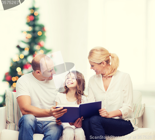 Image of happy family with book at home