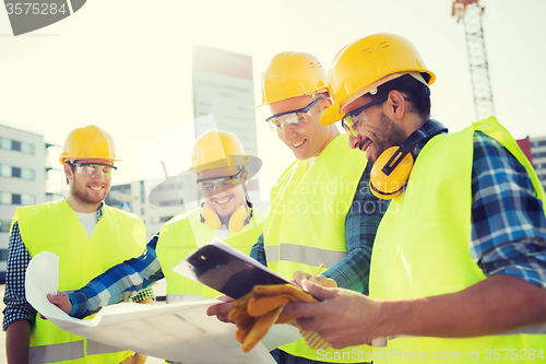 Image of group of builders with tablet pc and blueprint