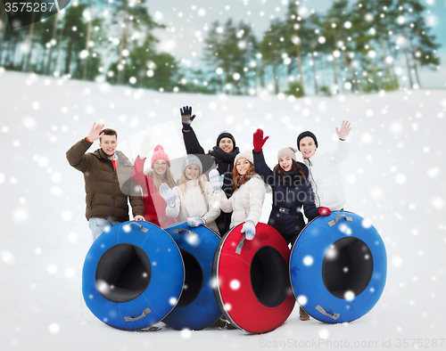 Image of group of smiling friends with snow tubes