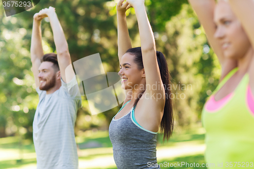 Image of group of friends or sportsmen exercising outdoors