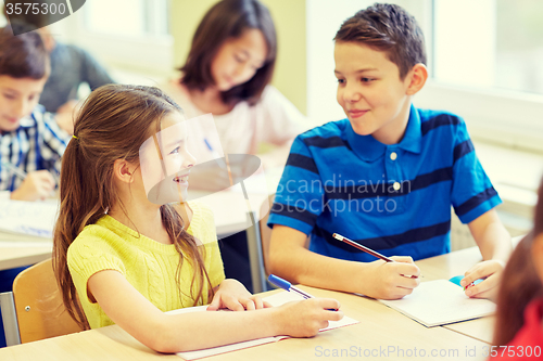 Image of group of school kids writing test in classroom