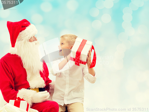 Image of smiling little boy with santa claus and gifts