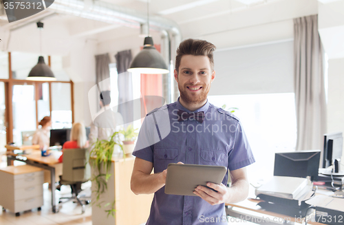 Image of happy creative male office worker with tablet pc