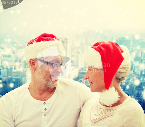 Image of happy senior couple in santa helper hats