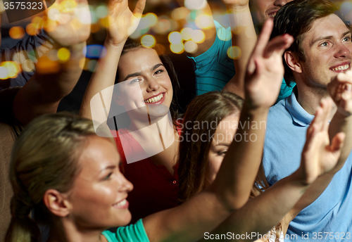 Image of smiling friends at concert in club