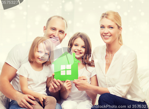 Image of happy family with two kids and paper house at home