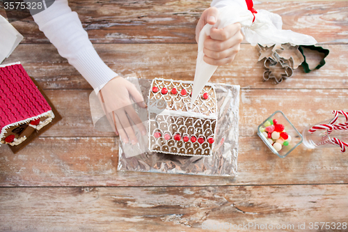 Image of close up of woman making gingerbread houses