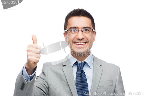 Image of happy businessman in eyeglasses showing thumbs up