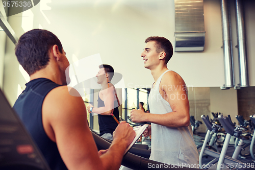 Image of men exercising on treadmill in gym