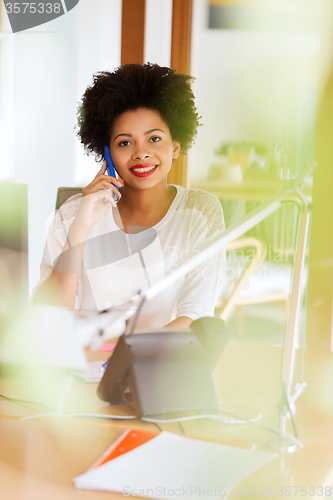 Image of businesswoman calling on smartphone at office