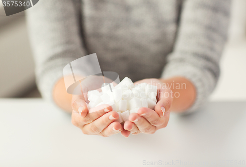 Image of close up of white lump sugar in woman hands