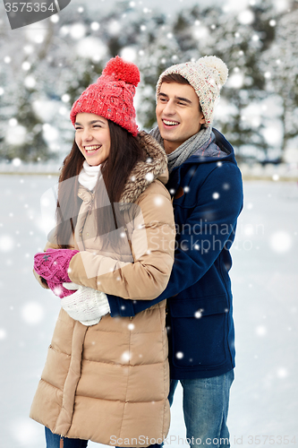 Image of happy couple ice skating on rink outdoors