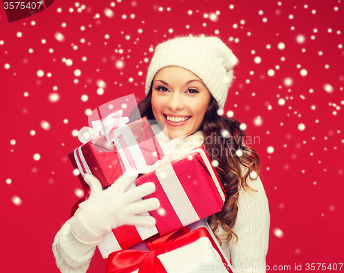 Image of woman in sweater and hat with many gift boxes