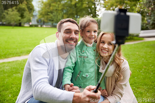 Image of happy family taking selfie by smartphone outdoors