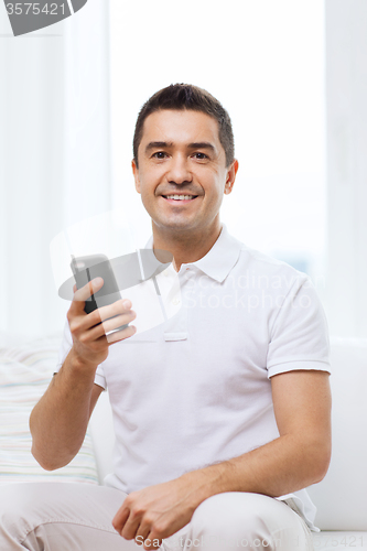 Image of happy man with smartphone at home