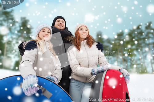 Image of group of smiling friends with snow tubes