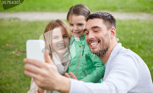 Image of happy family taking selfie by smartphone outdoors