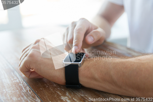 Image of close up of male hands setting smart watch