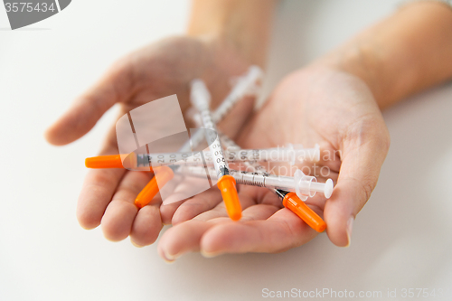 Image of close up of woman hands holding insulin syringes