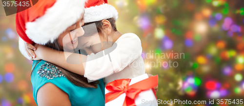 Image of happy mother and little girl in santa hats