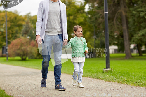 Image of happy family walking in summer park