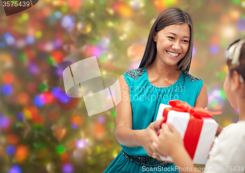 Image of happy mother giving christmas present to her child