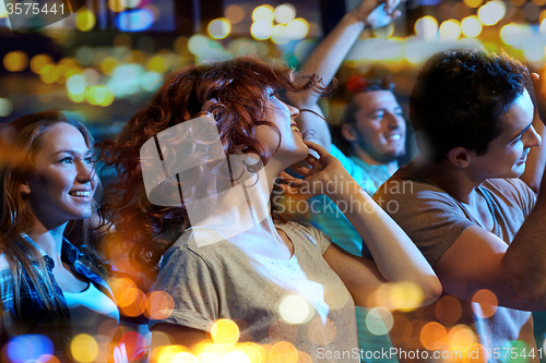 Image of happy friends dancing at night club