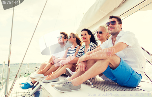 Image of smiling friends sitting on yacht deck