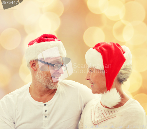 Image of happy senior couple in santa helper hats