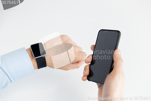 Image of close up of hands with smart phone and watch