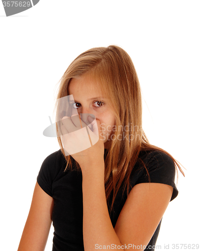 Image of Young girl closing her nose with hand.
