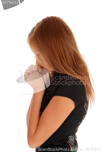 Image of Girl standing in profile and praying.