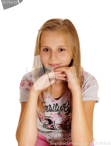 Image of A sad looking young girl sitting on chair.
