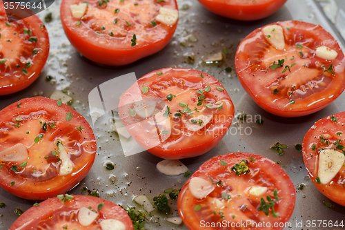 Image of Tomato halves for ready roasting, with garlic, thyme and oil
