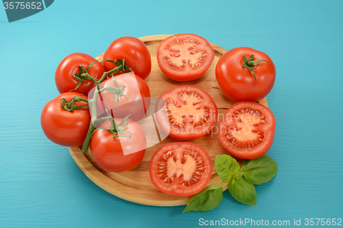 Image of Tomatoes - cut, whole and on the vine with fresh basil