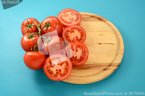 Image of Vine tomatoes whole and halved on a circular board