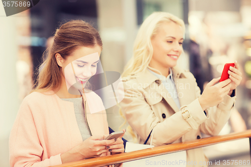 Image of happy women with smartphones and shopping bags