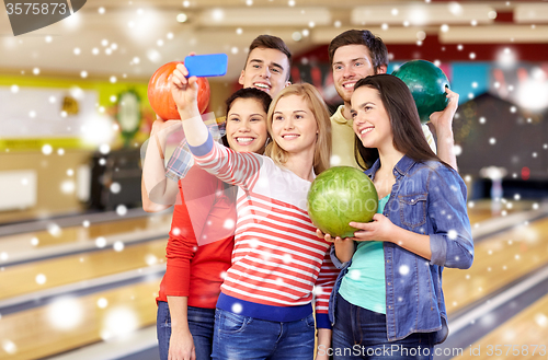 Image of happy friends with smartphone in bowling club